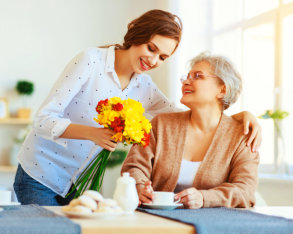 caregiver giving flowers to senior