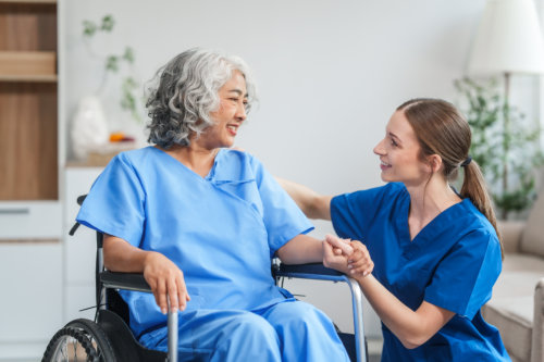 Friendly Nurse Caring for Senior Woman in Wheelchair